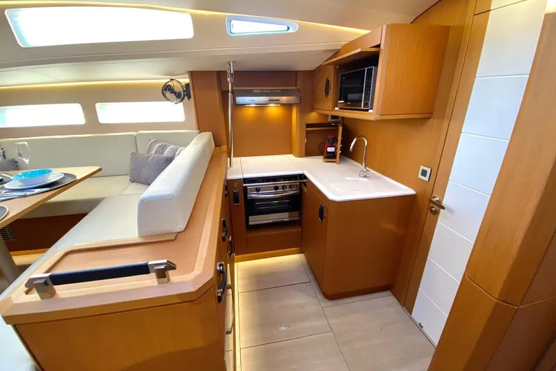 Euphoria Yacht Photos Pics Modern kitchen interior of 2021 Jeanneau 60 yacht with wood finish and appliances.