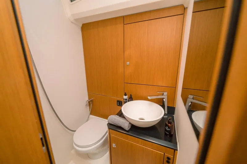 Euphoria Yacht Photos Pics Modern bathroom in 2021 Jeanneau 60 yacht with sleek wood cabinetry and vessel sink.