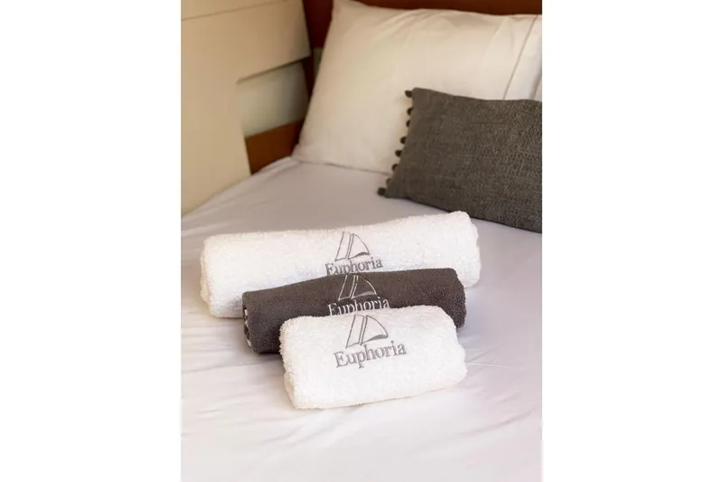 Euphoria Yacht Photos Pics Luxury towels on Jeanneau 60 yacht bed, 2021 model, with "Euphoria" branding.