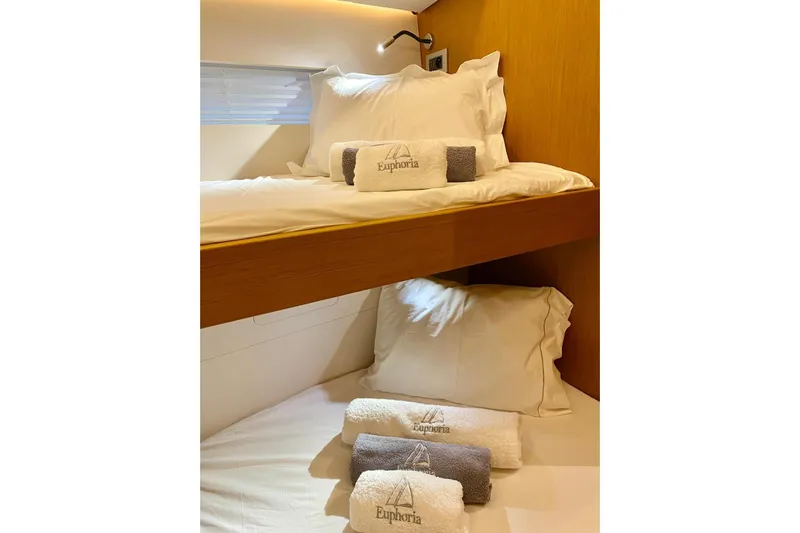 Euphoria Yacht Photos Pics Luxurious cabin interior of 2021 Jeanneau 60 yacht with cozy bedding and towels.