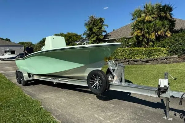 Wicked Tuna Yacht Photos Pics Custom Vernese V23 boat on trailer, parked on driveway, surrounded by greenery.
