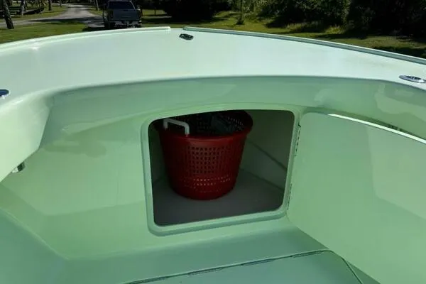 Wicked Tuna Yacht Photos Pics Open storage compartment on a 2021 Custom Vernese V23 boat with a red basket inside.