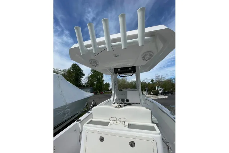 Century 2400cc Yacht Photos Pics 2022 Century 2400 Center Console boat with rod holders and steering console under blue sky.