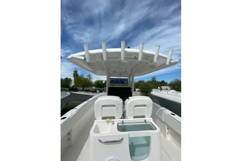 Century 2400cc Yacht Photos Pics 2022 Century 2400 Center Console boat with seating and rod holders under a blue sky.