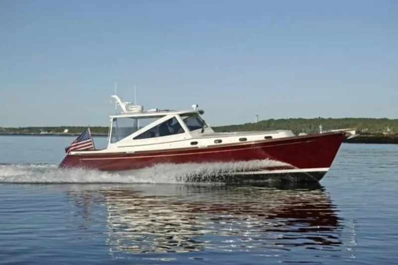 Skylark Yacht Photos Pics 2005 Lyman-Morse Monhegan boat cruising on calm water with American flag.