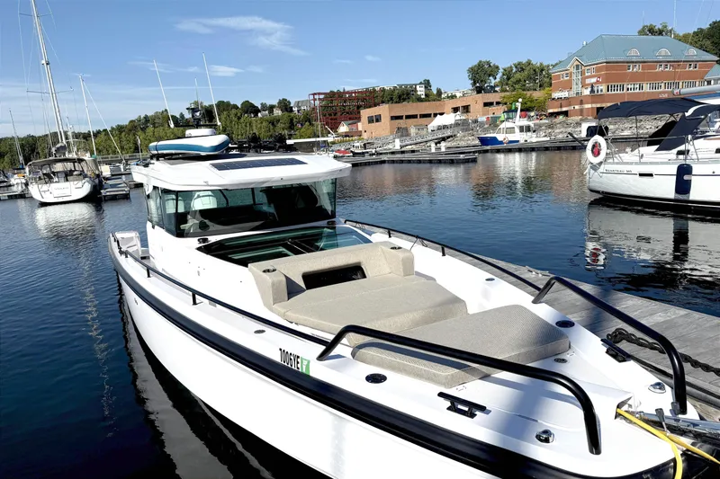  Yacht Photos Pics 2025 Axopar 37 XC CROSS CABIN boat docked in a marina, surrounded by other vessels.