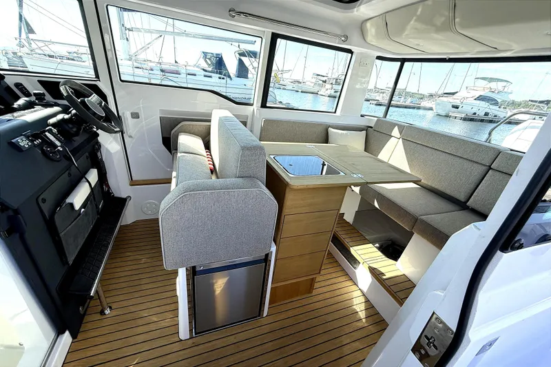  Yacht Photos Pics Interior of 2025 Axopar 37 XC CROSS CABIN with seating and table, docked at marina.