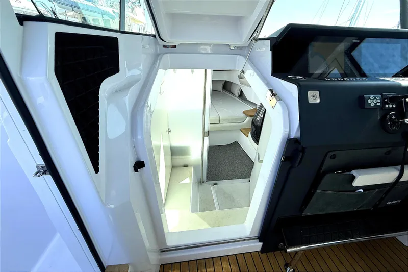  Yacht Photos Pics Interior view of 2025 Axopar 37 XC CROSS CABIN, showcasing cabin entrance and helm controls.