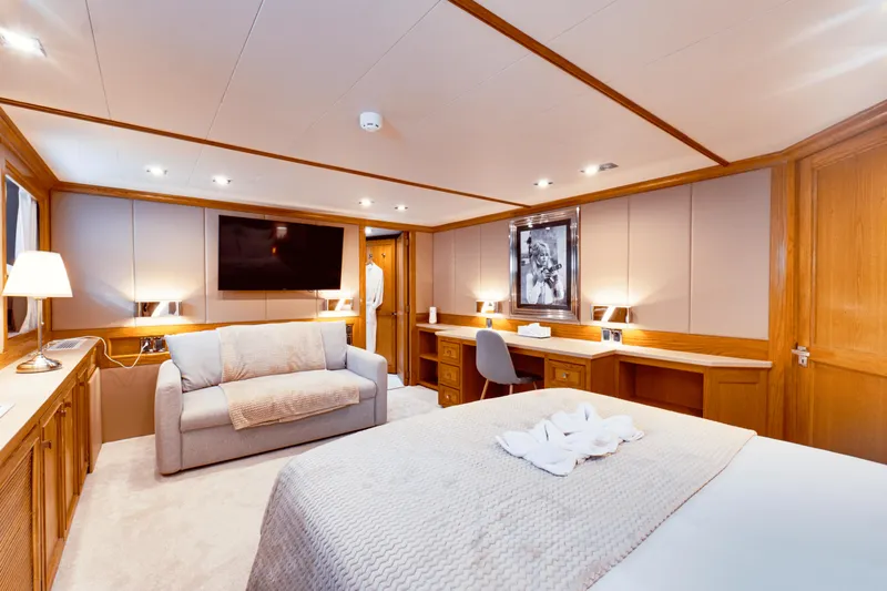 Eva Yacht Photos Pics Luxurious cabin interior of 1992 Cheoy Lee Custom yacht with bed, sofa, desk, and TV.