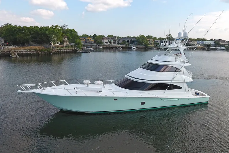 On The Edge Yacht Photos Pics 2018 Viking 80 Enclosed Skybridge yacht on calm water, surrounded by scenic shoreline.