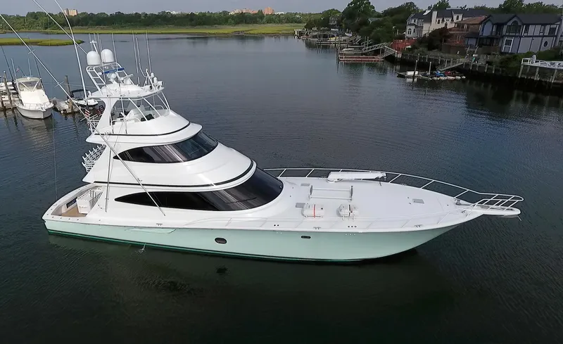 On The Edge Yacht Photos Pics 2018 Viking 80 Enclosed Skybridge yacht on calm water near shoreline homes.