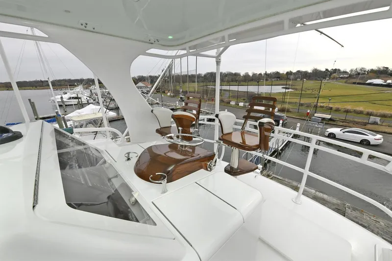 On The Edge Yacht Photos Pics Viking 80 Enclosed Skybridge yacht, 2018 model, featuring elegant seating and scenic marina view.