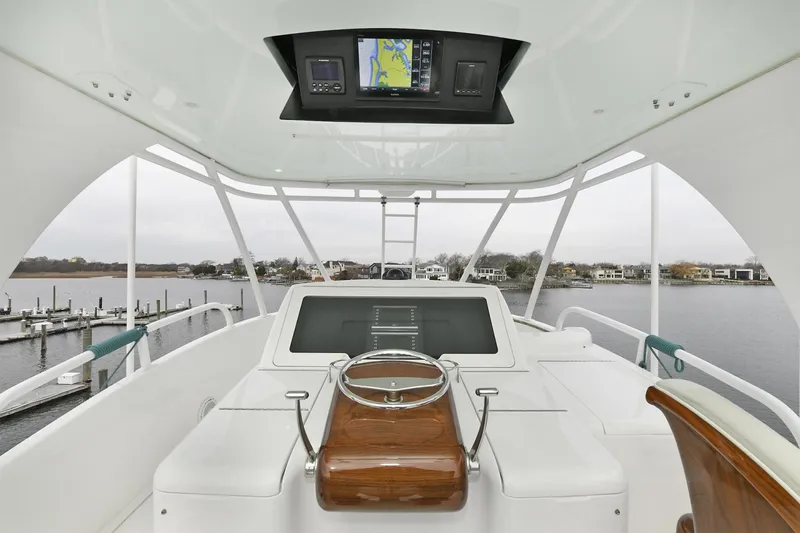 On The Edge Yacht Photos Pics 2018 Viking 80 Enclosed Skybridge yacht helm with navigation display, overlooking marina.