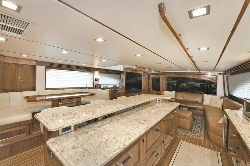 On The Edge Yacht Photos Pics Luxurious interior of 2018 Viking 80 Enclosed Skybridge yacht with elegant seating and marble countertops.