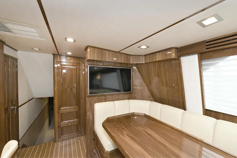 On The Edge Yacht Photos Pics Luxurious interior of 2018 Viking 80 Enclosed Skybridge yacht with wood paneling and seating.