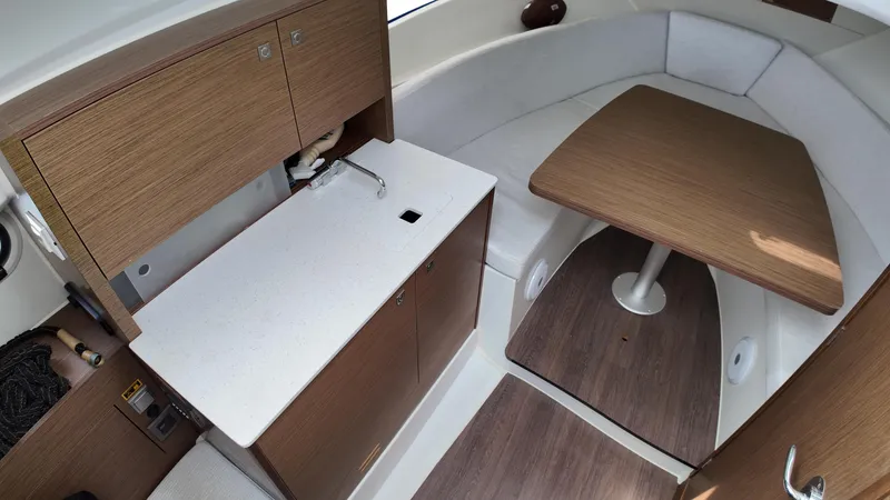  Yacht Photos Pics 2022 Jeanneau Leader 9.0 WA interior with kitchenette and seating area.