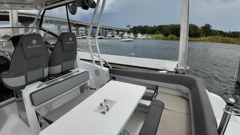  Yacht Photos Pics 2022 Jeanneau Leader 9.0 WA boat interior with seating and table, docked near a marina.