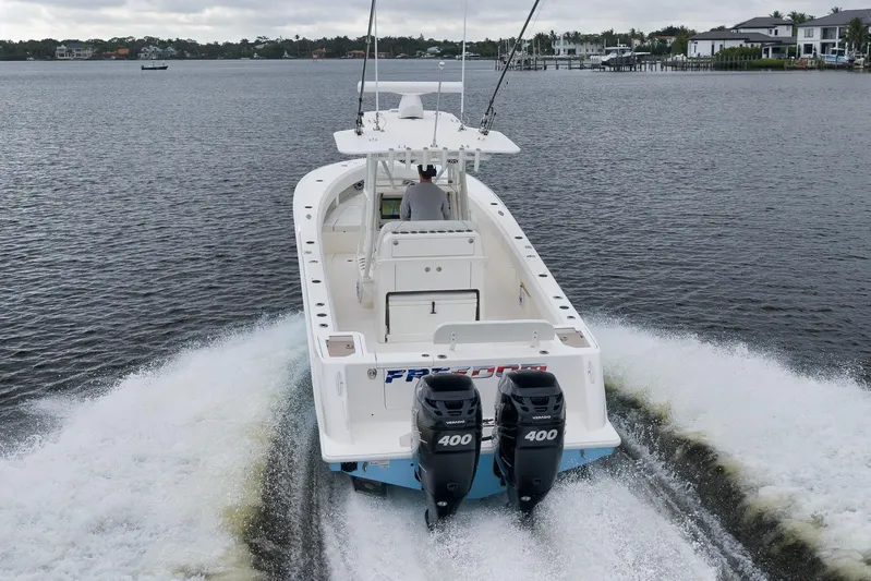  Yacht Photos Pics 2023 SeaVee 322Z boat cruising on a calm waterway, rear view.