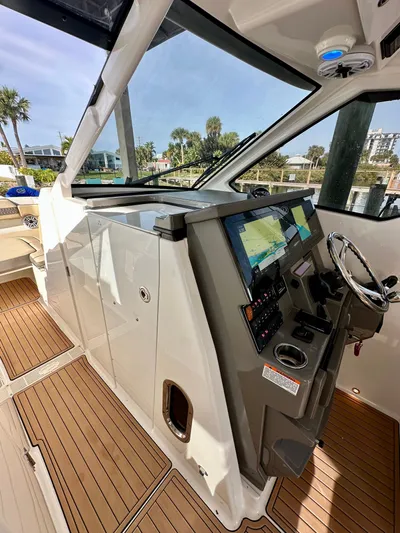 Breeezy Yacht Photos Pics 2020 Pursuit DC 365 Dual Console boat helm with wood flooring.
