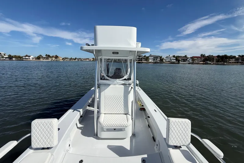  Yacht Photos Pics 2024 East Cape 25 Hybrid boat on calm water, clear sky, coastal homes in background.