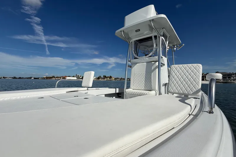  Yacht Photos Pics 2024 East Cape 25 Hybrid boat with white seating on calm water under blue sky.