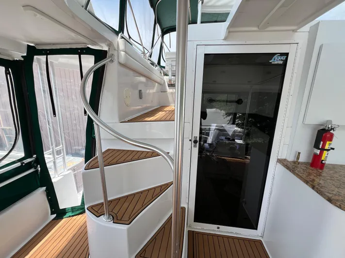 Amities Yacht Photos Pics 1998 Mainship 47 Motor Yacht interior with spiral staircase and glass door.