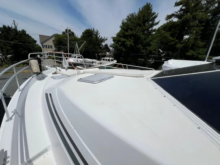 Amities Yacht Photos Pics 1998 Mainship 47 Motor Yacht deck view with trees and houses in the background.