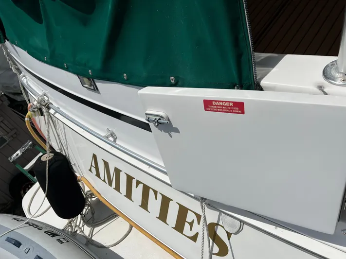 Amities Yacht Photos Pics 1998 Mainship 47 Motor Yacht with green cover and safety warning sign.