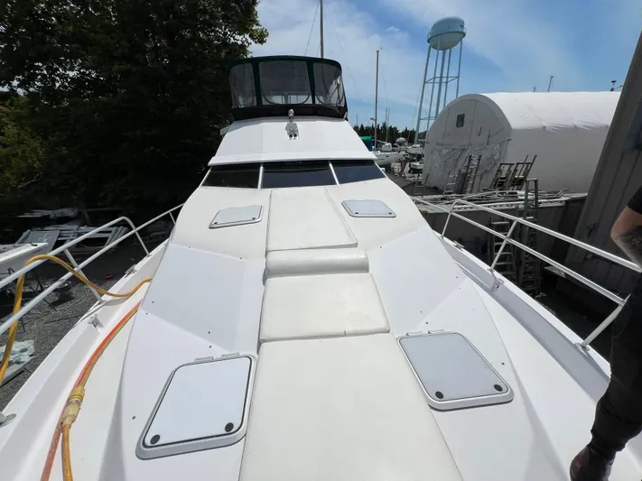 Amities Yacht Photos Pics 1998 Mainship 47 Motor Yacht deck view, docked with surrounding marina and water tower.