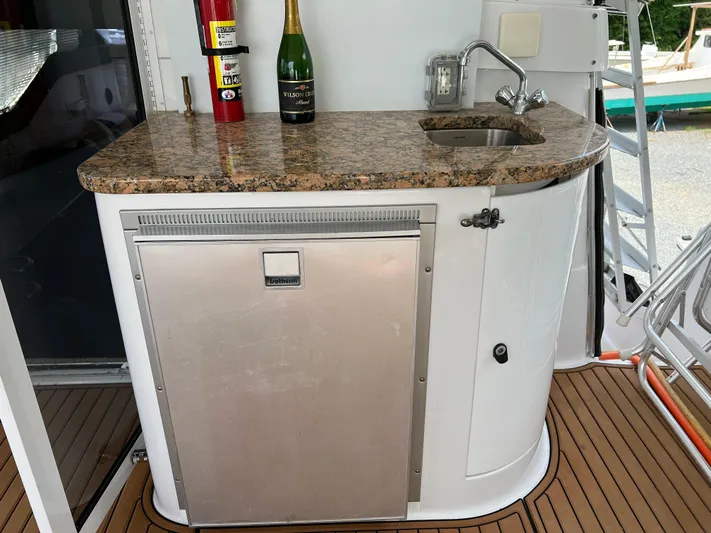 Amities Yacht Photos Pics 1998 Mainship 47 Motor Yacht wet bar with granite countertop and stainless steel fridge.