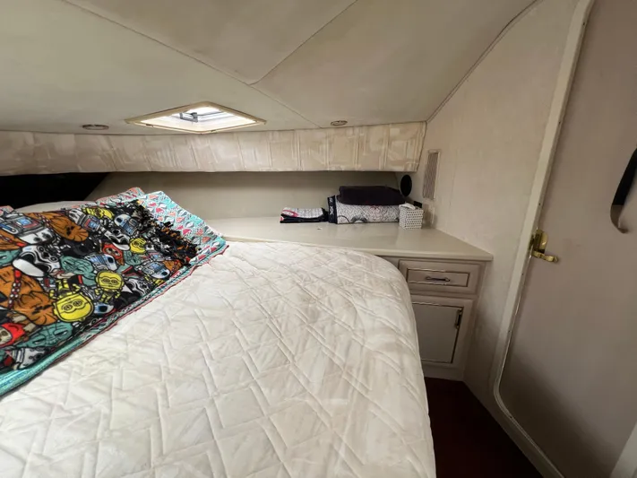 Amities Yacht Photos Pics Cozy bedroom interior of 1998 Mainship 47 Motor Yacht with colorful bedding and storage.