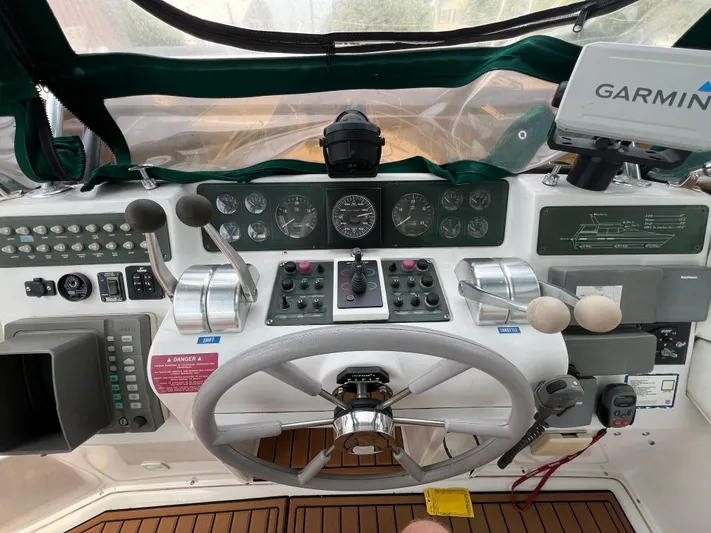 Amities Yacht Photos Pics Control panel of a 1998 Mainship 47 Motor Yacht with steering wheel and navigation equipment.