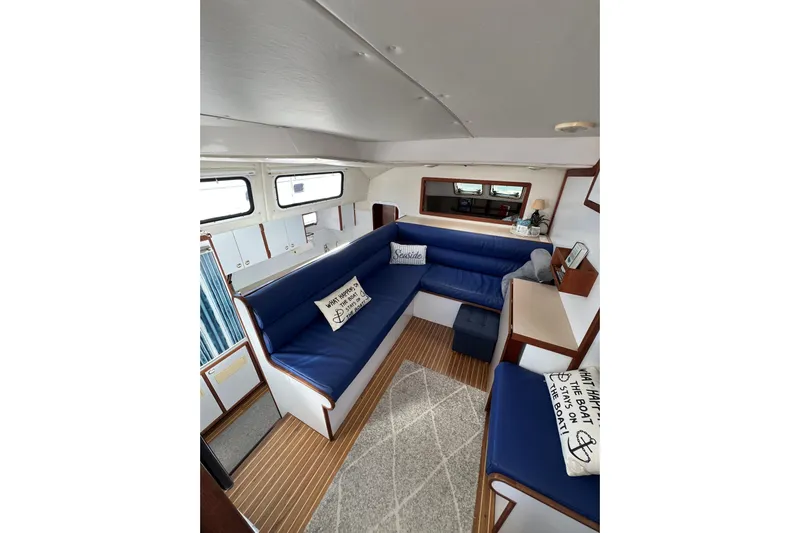 Sea Change Yacht Photos Pics Interior of 2003 Endeavour 36 TrawlerCat with blue seating and nautical decor.