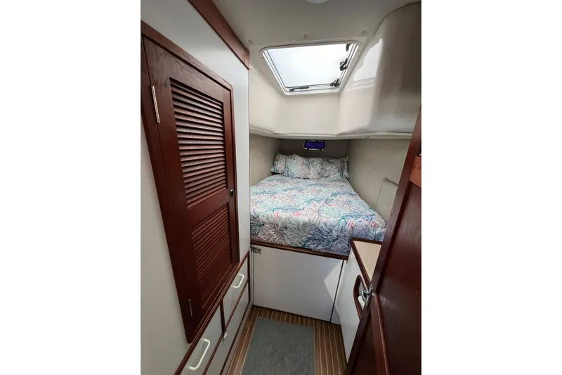 Sea Change Yacht Photos Pics Cozy cabin interior of 2003 Endeavour 36 TrawlerCat with bed and wooden cabinetry.