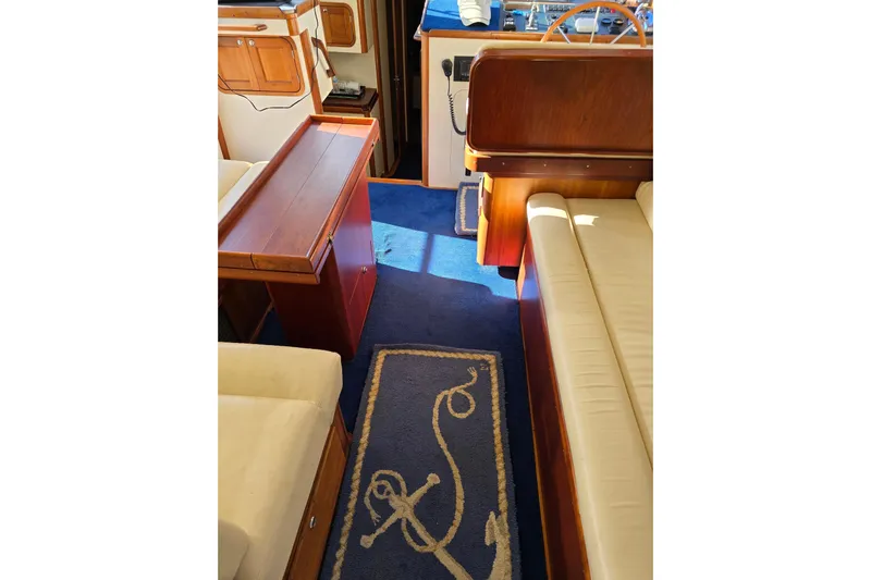 Lindy Yacht Photos Pics Interior of 2004 Legacy Yachts Sedan Flybridge with blue carpet and wooden furnishings.