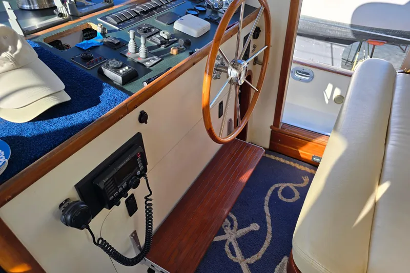 Lindy Yacht Photos Pics 2004 Legacy Yachts Sedan Flybridge helm with wooden steering wheel and navigation controls.