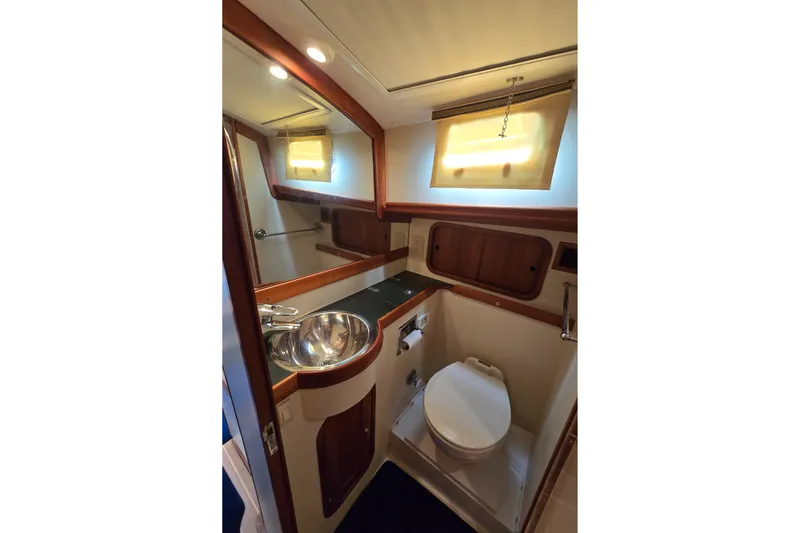 Lindy Yacht Photos Pics 2004 Legacy Yachts Sedan Flybridge bathroom with sink, toilet, and wooden accents.