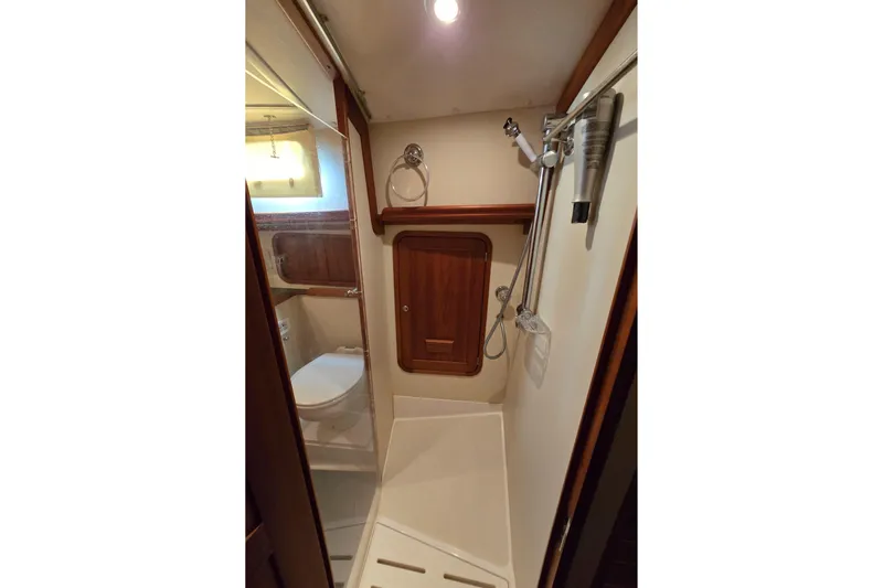 Lindy Yacht Photos Pics 2004 Legacy Yachts Sedan Flybridge bathroom with shower, wooden accents, and modern fixtures.