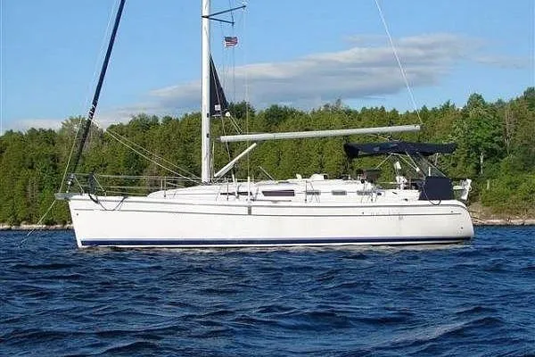 Windependence Yacht Photos Pics 2006 Hunter 38 sailboat on a lake, surrounded by lush green trees.