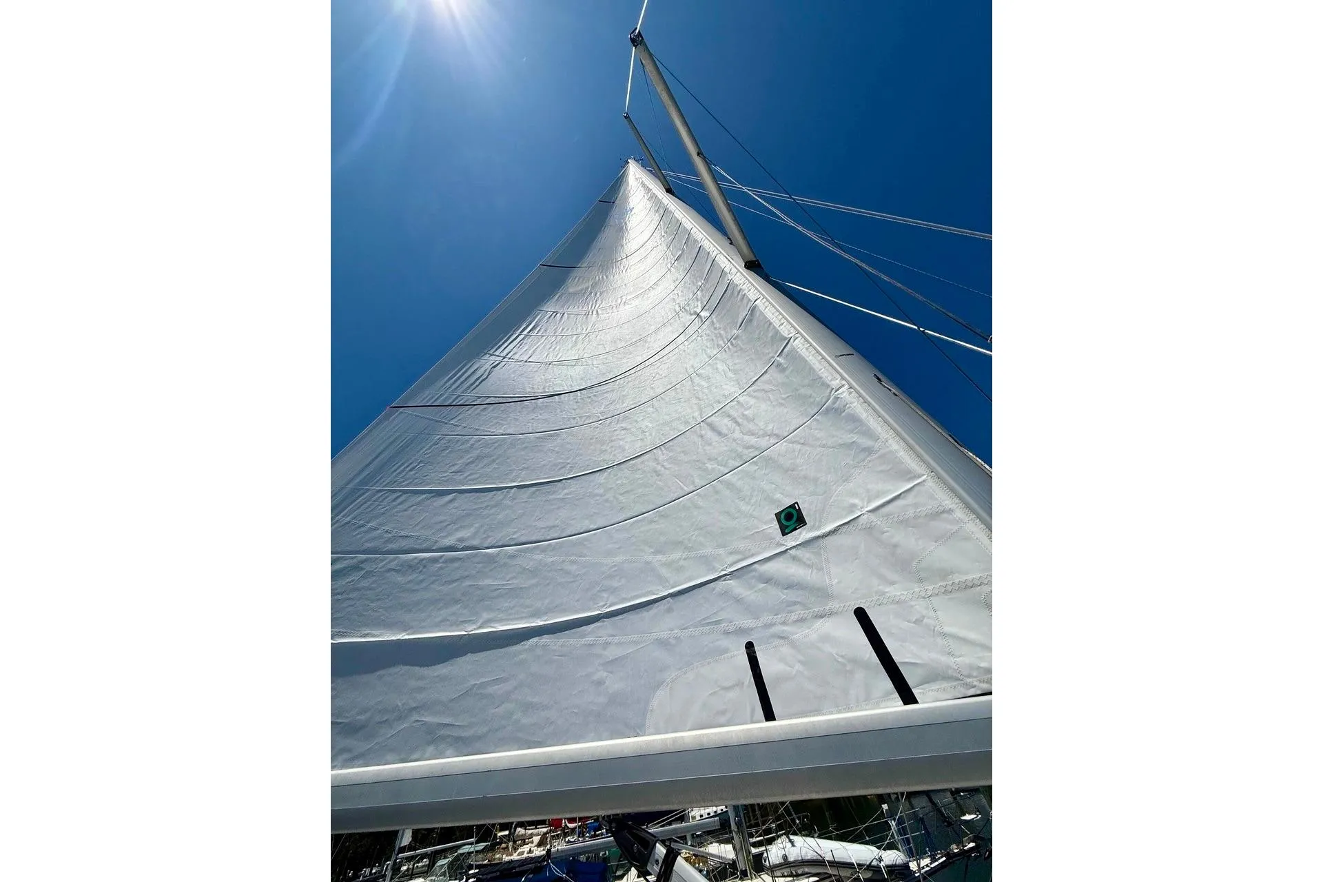 Sail of a 2006 Hunter 38 yacht against a clear blue sky.