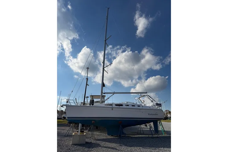 Windependence Yacht Photos Pics 2006 Hunter 38 sailboat on land under a blue sky with clouds.
