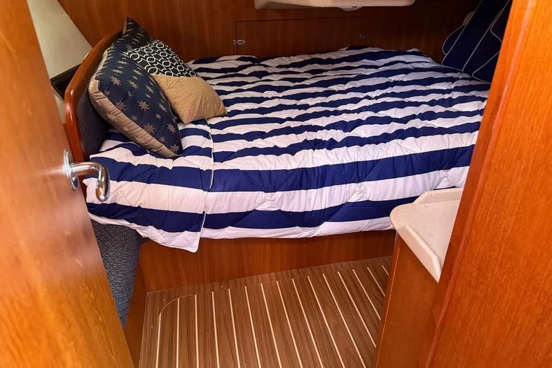 Windependence Yacht Photos Pics Cozy cabin interior of 2006 Hunter 38 sailboat with striped bedding and pillows.