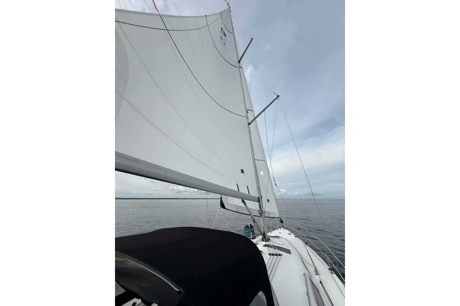 Sailing on a 2006 Hunter 38 yacht with full sails on a calm sea.