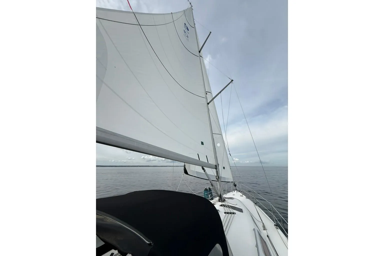 Sailing on a 2006 Hunter 38 yacht with full sails on a calm sea.