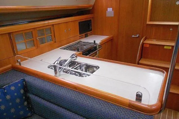 Windependence Yacht Photos Pics 2006 Hunter 38 yacht interior with modern kitchen, featuring stove, sink, and wooden cabinetry.
