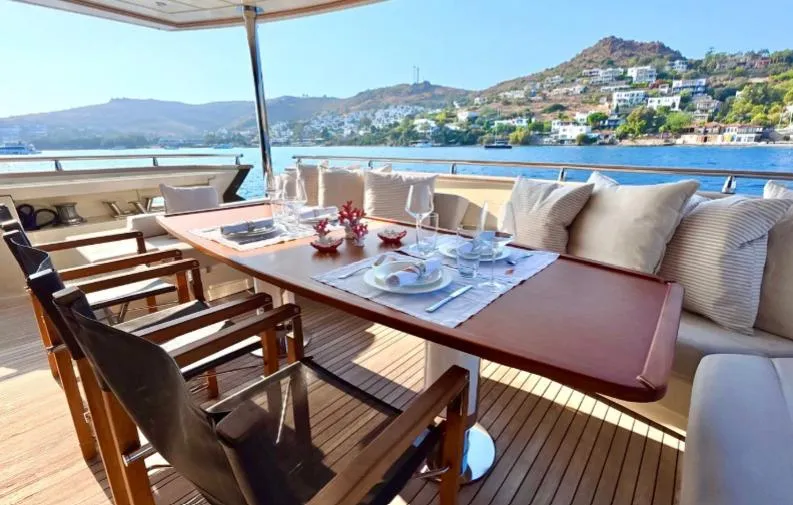  Yacht Photos Pics Luxurious dining area on 2007 Riva 115 Athena yacht with scenic coastal view.