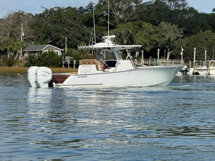  Yacht Photos Pics 2020 Valhalla Boatworks V-33 cruising on a calm river near a wooded shoreline.