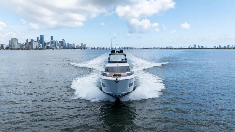 Giulia Yacht Photos Pics 2023 Ferretti Yachts 670 cruising on water with city skyline in background.