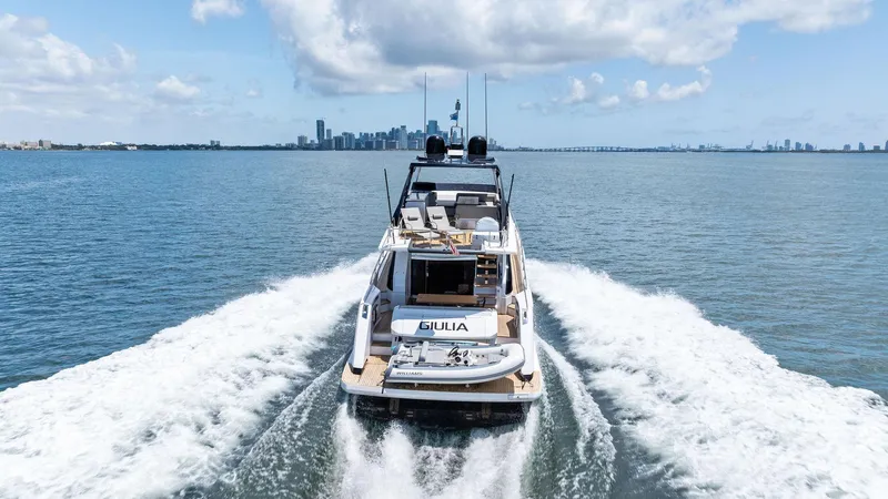 Giulia Yacht Photos Pics 2023 Ferretti Yachts 670 cruising on open water with city skyline in background.