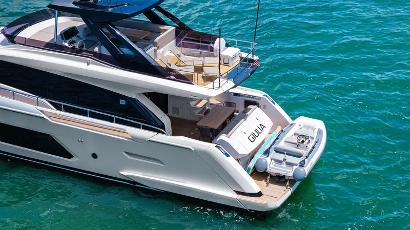 Giulia Yacht Photos Pics 2023 Ferretti Yachts 670 luxury yacht on clear blue water, rear view.